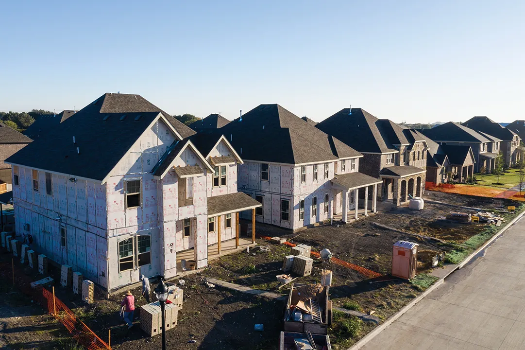 A set of new homes being built in a large neighborhood.