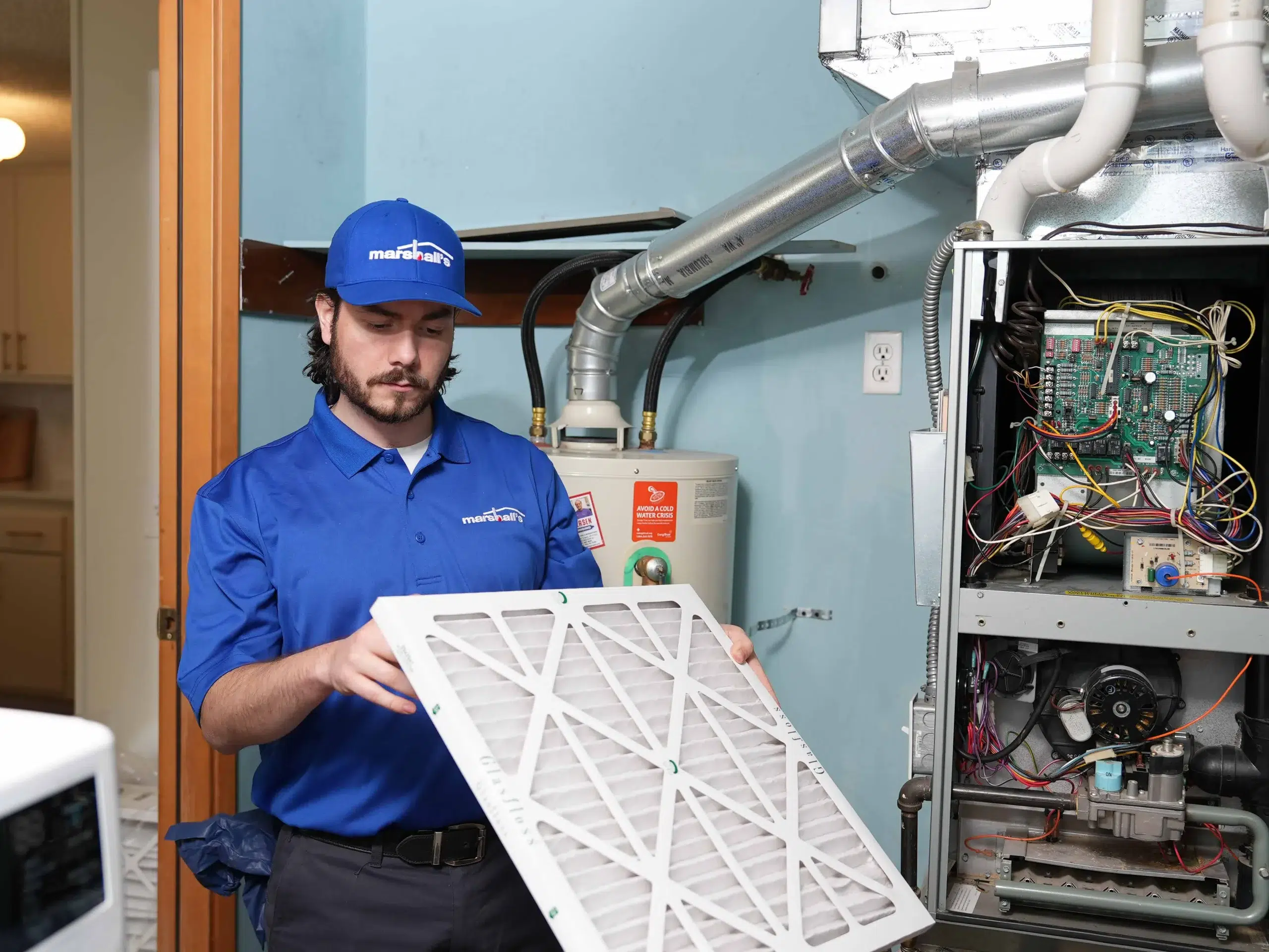 An expert Marshall's HVAC technician inspects a home's air filter.