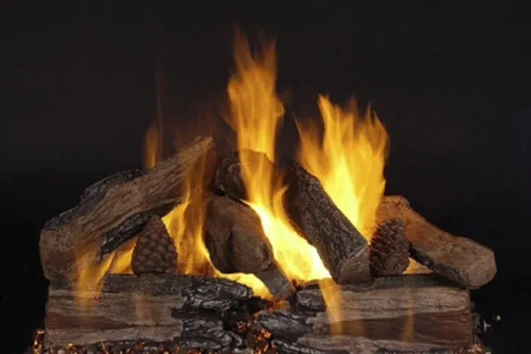 A collection of burning logs in an indoor fireplace.
